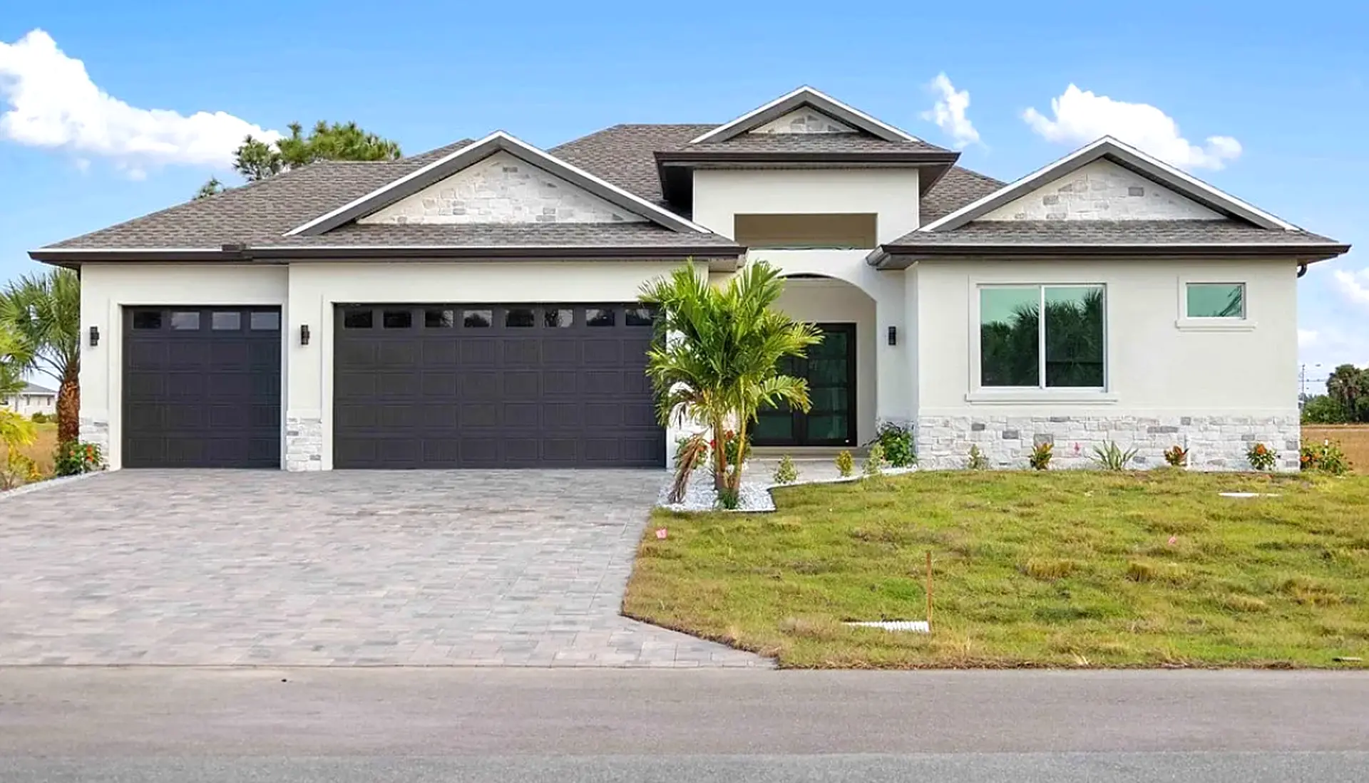 Finished Hivesta home with stone gables, palms and a three-car garage