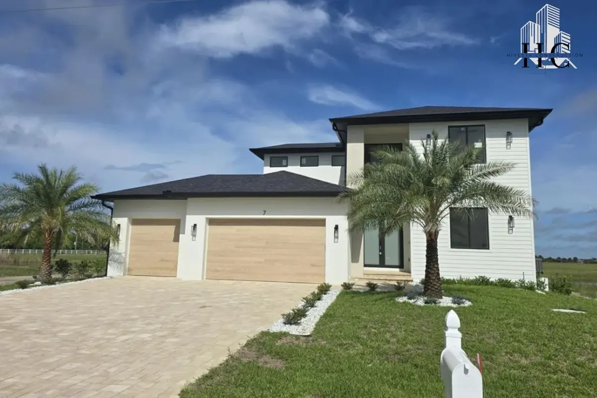 Finished two-story Mena model home with a three-car garage and palms
