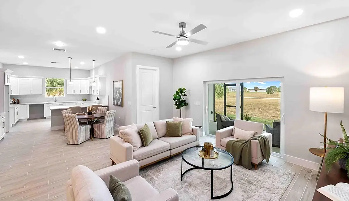 Staged living room open to the kitchen and lanai doors
